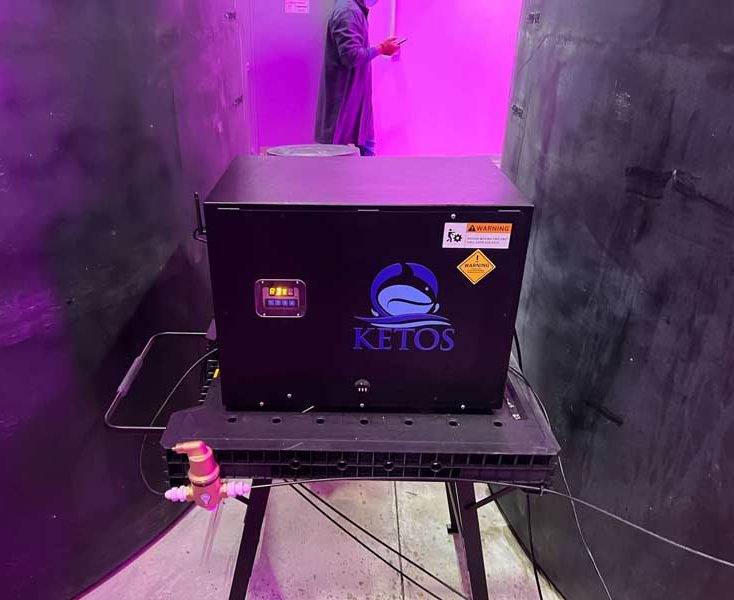 KETOS water quality monitoring equipment connected to hydroponic plumbing in a vertical farming facility