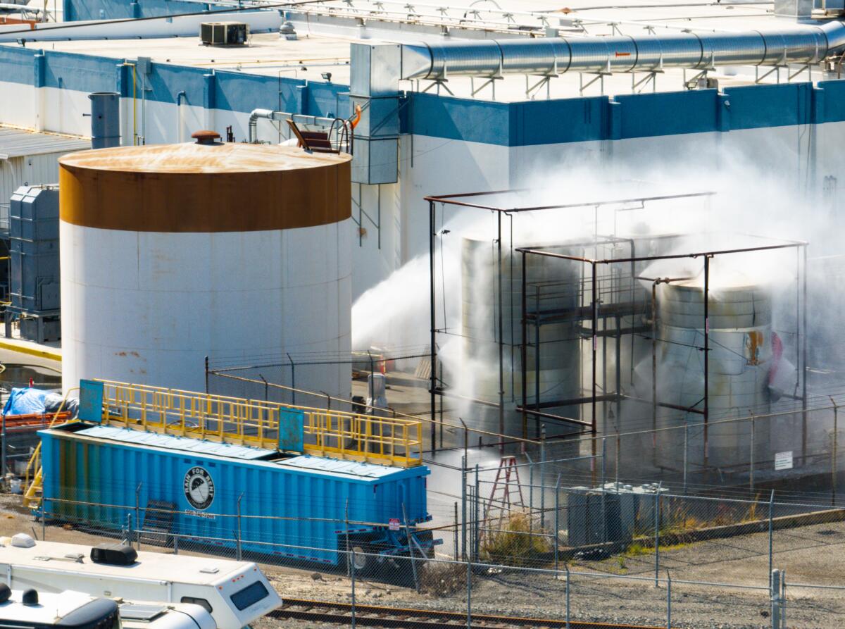 Exterior of the GKN Aerospace facility in Garden Grove during the chemical leak crisis with emergency response vehicles and caution signage visible