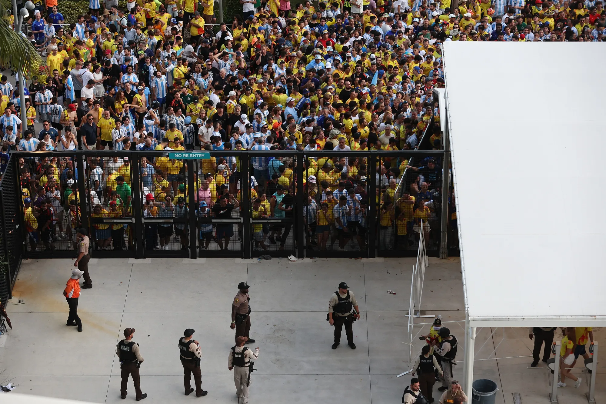 Crowds pressing against and breaching security gates outside Hard Rock Stadium before the 2024 Copa America final