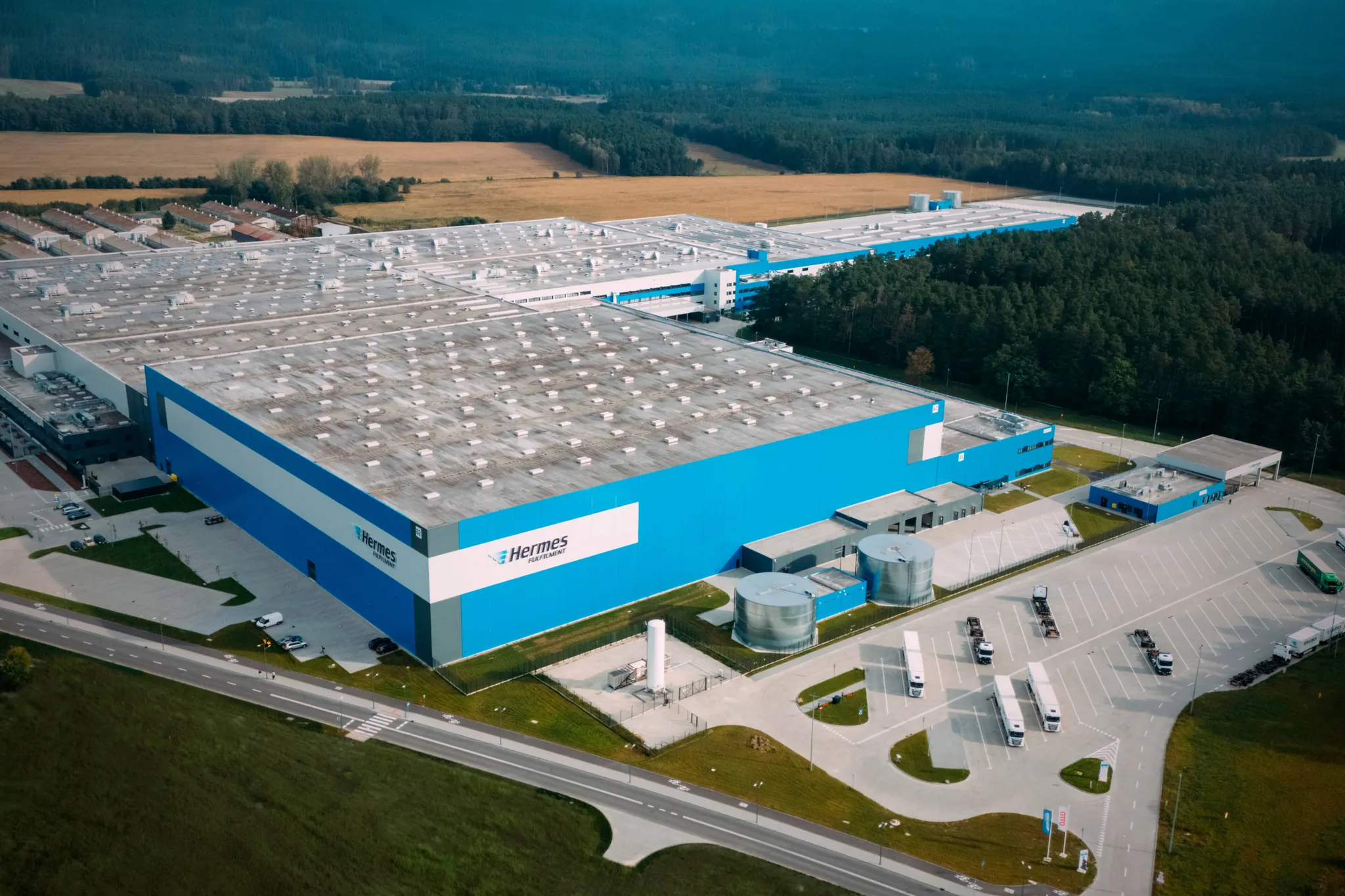Aerial view of OTTO Group's Ilowa logistics distribution center with warehouse buildings and truck loading areas
