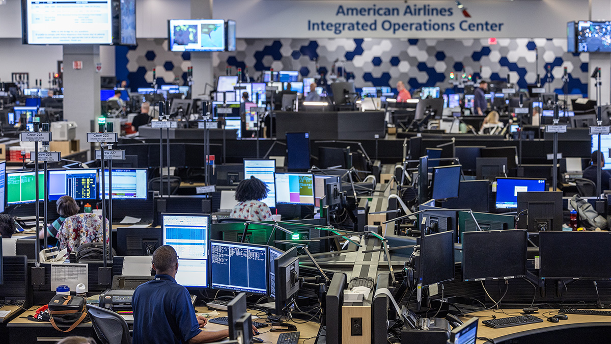 American Airlines Integrated Operations Center with live flight network displays and rows of operations workstations