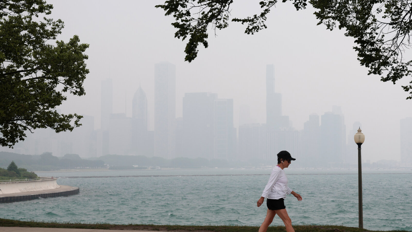 Chicago skyline shrouded in orange-gray wildfire smoke haze with reduced visibility
